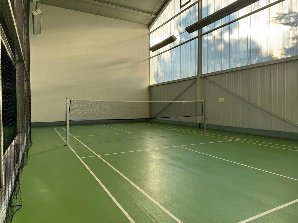 Sportliche Spielflächen mit grünem Bodenbelag in der Tennis- und Badmintonhalle Berwangen